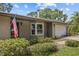 Charming home featuring an attached two car garage, well-maintained landscaping, and an American flag on display at 310 E Gulley Ave, Oakland, FL 34760
