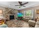 Cozy living room showcasing a floor-to-ceiling stone fireplace, wood-look flooring, and a large bay window at 310 E Gulley Ave, Oakland, FL 34760