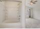 Bright bathroom featuring a bathtub and shower combo with tiled walls and shelving at 4178 Sw 43Rd Cir, Ocala, FL 34474