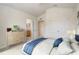 Staged bedroom featuring blue bedding, a side table, and a dresser with views into the bathroom and hallway at 4178 Sw 43Rd Cir, Ocala, FL 34474