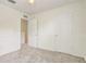 A bedroom with neutral colored carpet and walls, a doorway, and a closet with paneled doors at 4178 Sw 43Rd Cir, Ocala, FL 34474