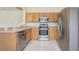 Kitchen with stainless steel appliances, light wood cabinets and white tile floors at 4178 Sw 43Rd Cir, Ocala, FL 34474