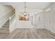 Bright open-concept living area leading to kitchen with light floors and staircase at 4178 Sw 43Rd Cir, Ocala, FL 34474