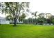 Expansive green lawn with trees and a view of the pool area, offering a serene outdoor space at 4364 White Pine Ave # 3, Orlando, FL 32811