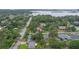 Scenic aerial view showcases a house in a lush, wooded neighborhood with a lake nearby at 4420 Conway Gardens Rd, Orlando, FL 32806