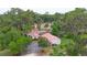 Expansive single-story home with a red tiled roof, surrounded by mature trees, in an aerial view at 4420 Conway Gardens Rd, Orlando, FL 32806