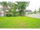The yard features lush green grass, mature trees and a fenced property line at 4420 Conway Gardens Rd, Orlando, FL 32806