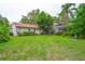 The backyard features a large lawn, mature trees, and an enclosed porch at 4420 Conway Gardens Rd, Orlando, FL 32806