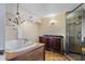 Luxurious bathroom featuring a large bathtub, tile floors, a dark vanity, and an enclosed glass shower at 4420 Conway Gardens Rd, Orlando, FL 32806
