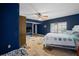Bedroom with blue walls, a ceiling fan, and tile floors, complemented by a bed with a patterned comforter at 4420 Conway Gardens Rd, Orlando, FL 32806