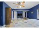 A bedroom with blue walls, ceiling fan, and tile flooring features natural light from the window at 4420 Conway Gardens Rd, Orlando, FL 32806