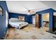 Bedroom with blue walls and tan tile flooring includes natural light from the window and en-suite bathroom access at 4420 Conway Gardens Rd, Orlando, FL 32806