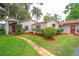 Stucco home with red tile roof, lush landscaping, and a brick walkway leading to the front entrance at 4420 Conway Gardens Rd, Orlando, FL 32806