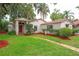 Charming one-story home with red front door, terracotta roof, and lush landscaping at 4420 Conway Gardens Rd, Orlando, FL 32806