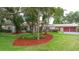 Charming single-story home with red mulch, lush lawns, mature trees, and a two-car garage at 4420 Conway Gardens Rd, Orlando, FL 32806