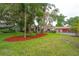 Expansive front yard with a well-manicured lawn and landscaping, showcasing a single-story home with an attached garage at 4420 Conway Gardens Rd, Orlando, FL 32806