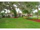 Sprawling front yard with a majestic tree draped with Spanish moss over a single-story home with a red tile roof at 4420 Conway Gardens Rd, Orlando, FL 32806