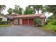 The exterior showcases a multi-car garage with red doors that complement the home's architecture at 4420 Conway Gardens Rd, Orlando, FL 32806