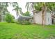Rear of the home featuring a pool enclosure, mature trees and green landscaping at 4420 Conway Gardens Rd, Orlando, FL 32806
