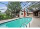 Enclosed pool area with shimmering water, complete with an attached cottage-like structure featuring a vibrant red chimney at 4420 Conway Gardens Rd, Orlando, FL 32806