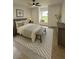 Cozy bedroom featuring a ceiling fan, a patterned rug, a bench, and a window seat overlooking a green view at 470 Sunset Rd, Deltona, FL 32725