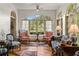 Bright sun room with terracotta floors, large arched windows, and comfortable seating with views of lush landscaping at 522 Cherokee Dr, Orlando, FL 32801