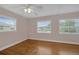 Bedroom with wood floors, three windows, and a ceiling fan at 663 Romano Ave, Orlando, FL 32807