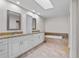 Bathroom featuring double vanities, soaking tub, tile flooring, and recessed lighting at 6766 Edgeworth Dr, Orlando, FL 32819