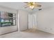 Carpeted bedroom with fan and window with a view of the backyard at 6766 Edgeworth Dr, Orlando, FL 32819