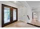 Foyer with tile flooring, staircase and stained-glass double doors at 6766 Edgeworth Dr, Orlando, FL 32819