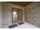 Covered front porch with double doors, brick exterior, and new door mats at 6766 Edgeworth Dr, Orlando, FL 32819