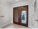 Elegant front entryway with ornate glass double doors and neutral tile flooring at 6766 Edgeworth Dr, Orlando, FL 32819