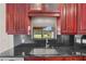 Close-up of a stainless steel sink set in black granite countertop at 6766 Edgeworth Dr, Orlando, FL 32819