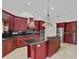 Well-appointed kitchen features custom cabinets, granite countertops, stainless steel appliances, and a large center island at 6766 Edgeworth Dr, Orlando, FL 32819