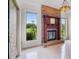 Living room with a brick fireplace and large windows providing views of the lush green backyard at 6766 Edgeworth Dr, Orlando, FL 32819