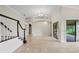 Expansive living room with tile flooring, staircase, columns, and sliding glass doors, seamlessly connecting indoor and outdoor spaces at 6766 Edgeworth Dr, Orlando, FL 32819