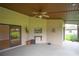 Spacious covered patio featuring ceiling fan with views of landscaped yard at 6766 Edgeworth Dr, Orlando, FL 32819