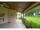Covered patio overlooking lush landscaping and a beautiful manicured lawn at 6766 Edgeworth Dr, Orlando, FL 32819
