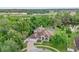 Expansive aerial view of single-Gathering home with screened pool, a large lot surrounded by mature trees and pond views at 701 Little Hampton Ln, Gotha, FL 34734