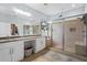 Bright bathroom with a spacious glass shower, double vanity, and travertine tile at 701 Little Hampton Ln, Gotha, FL 34734