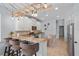 Open-concept kitchen with white cabinets, granite countertops, backsplash, an island counter, and bar stool seating at 701 Little Hampton Ln, Gotha, FL 34734