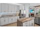 Spacious kitchen with white cabinets, granite countertops, stainless steel appliances, and a large island counter at 701 Little Hampton Ln, Gotha, FL 34734