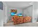 Inviting living room with a comfortable couch, beach art, and two TVs for relaxed entertainment at 701 Little Hampton Ln, Gotha, FL 34734
