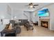 Cozy living room featuring a comfortable gray sofa, a fireplace with a TV, and neutral tile flooring at 701 Little Hampton Ln, Gotha, FL 34734