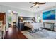 Bright primary bedroom featuring dark wood floors, area rug, king bed, and ceiling fan at 701 Little Hampton Ln, Gotha, FL 34734