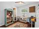 Organized home office showcasing custom desk, ample storage, and a decorative bookcase against a window at 701 Little Hampton Ln, Gotha, FL 34734
