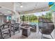 Covered patio with comfortable seating, fire pit, and view of screened pool, ideal for outdoor living at 701 Little Hampton Ln, Gotha, FL 34734