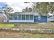 View of the house with a screened-in porch from the backyard featuring a retaining wall at 7504 Willow Wisp E Dr, Lakeland, FL 33810