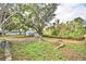 Backyard with a firepit, mature landscaping, and fencing at 7504 Willow Wisp E Dr, Lakeland, FL 33810