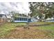 Spacious backyard with a screened-in porch featuring a retaining wall, offering lots of potential at 7504 Willow Wisp E Dr, Lakeland, FL 33810